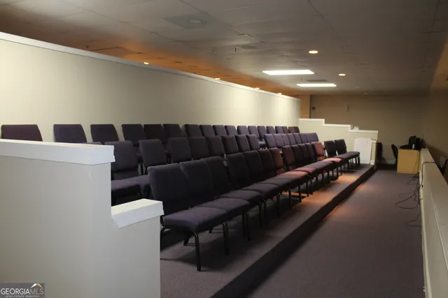 a white house with a large parking space and a car parked in front of it