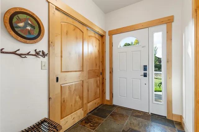 a view of a hallway with wooden floor and a bathroom view