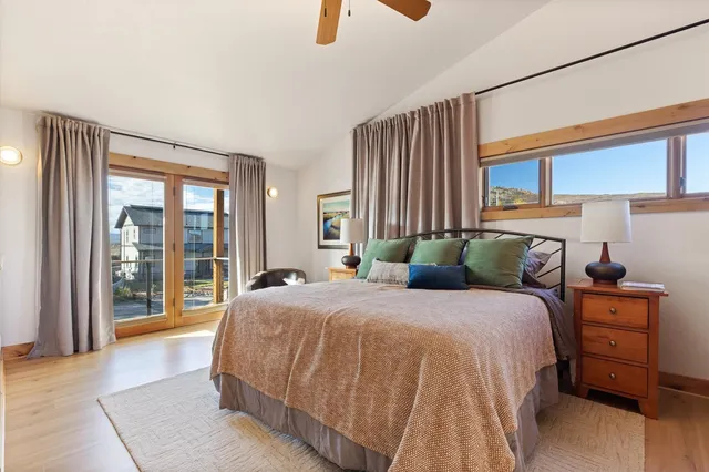 a bedroom with a bed and a large window