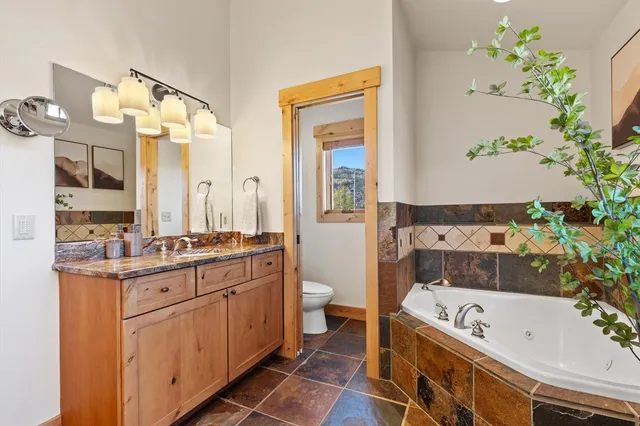 a bathroom with a tub a sink and a large mirror