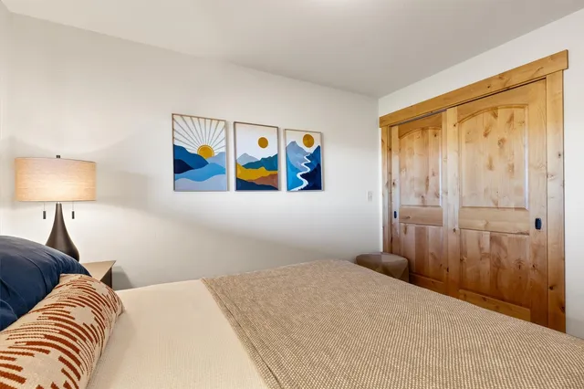 a bedroom with a bed and a painting on the wall