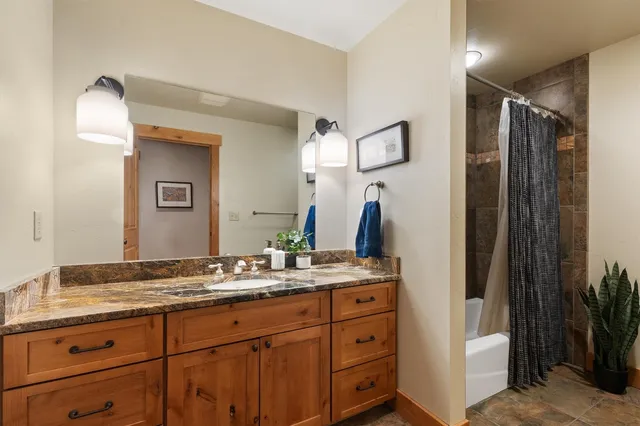 a spacious bathroom with a granite countertop sink and a mirror