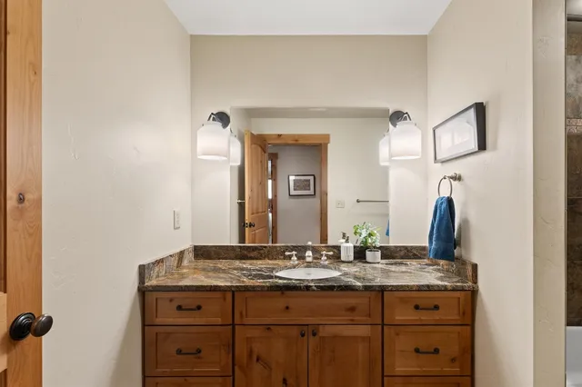 a bathroom with a granite countertop sink and a mirror