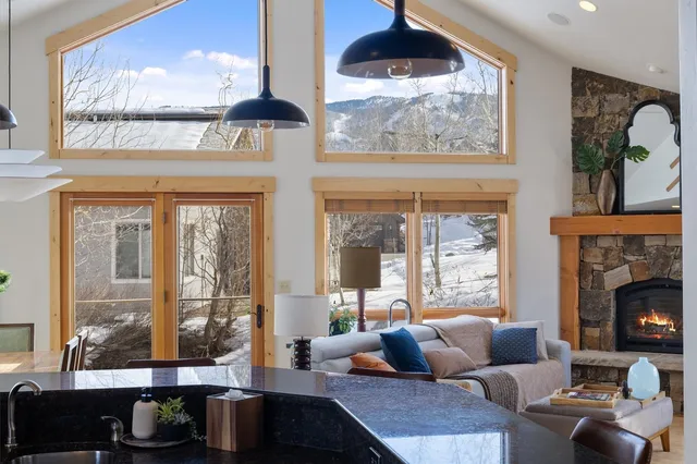 a living room with furniture a fireplace and a floor to ceiling window