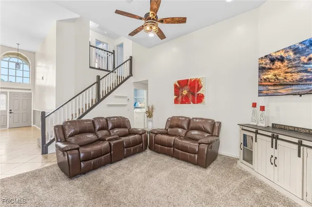 a living room with furniture kitchen view and a chandelier