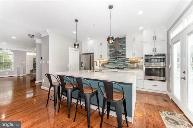 a kitchen with stainless steel appliances kitchen island granite countertop a table chairs sink and cabinets