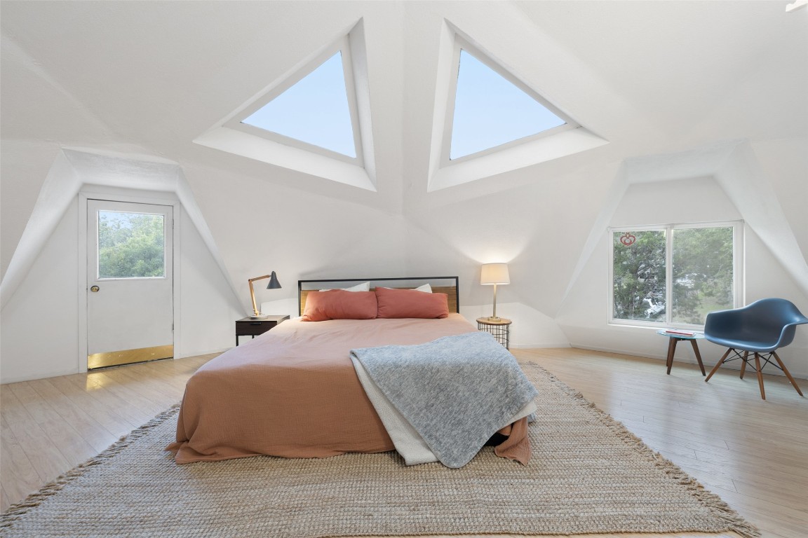 Bedroom with lofted ceiling and wood finished floors