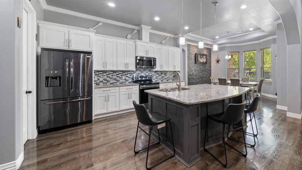 401 May Road Seagoville, TX 75159 - Photo 15 of 31 a kitchen with stainless steel appliances a dining table chairs stove refrigerator and microwave