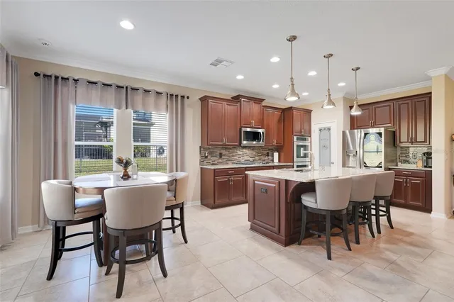 a kitchen with kitchen island granite countertop wooden cabinets and stainless steel appliances