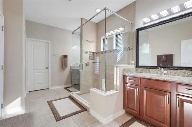 a spacious bathroom with a granite countertop sink mirror and shower