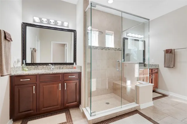 a bathroom with a shower a mirror and a sink
