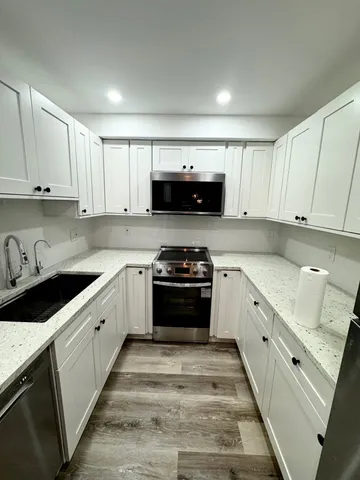 a kitchen with granite countertop a stove sink and cabinets