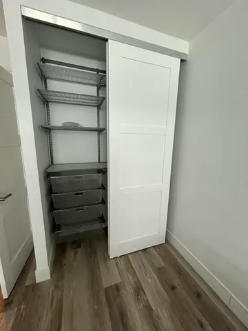 a view of walk in closet with empty racks