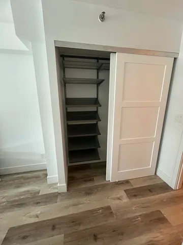 a view of walk in closet with empty racks
