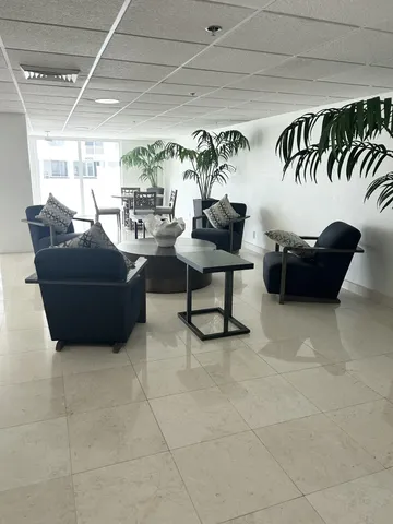 a living room with couches and a potted plant on a coffee table
