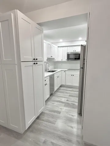 a kitchen with white cabinets and sink