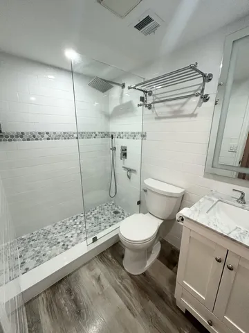 a bathroom with a granite countertop sink toilet and shower
