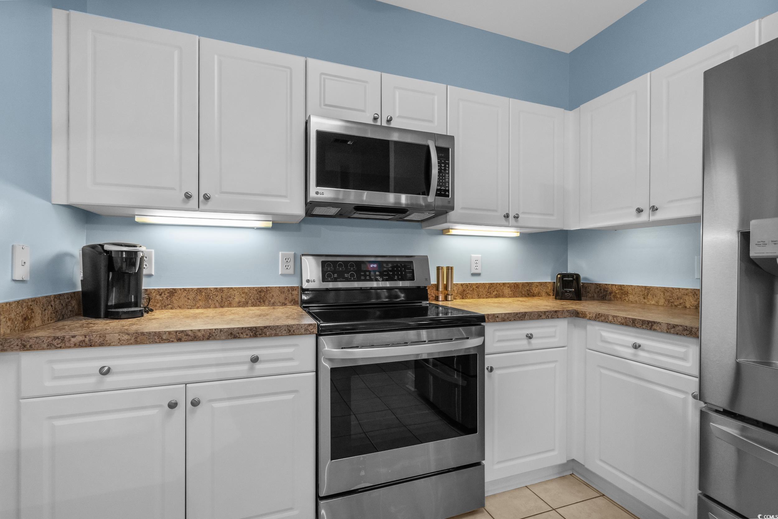 70 Addison Cottage Way, Unit 322 Murrells Inlet, SC 29576 - Photo 14 of 40 Kitchen with stainless steel appliances, white cabinets, and light tile patterned floors