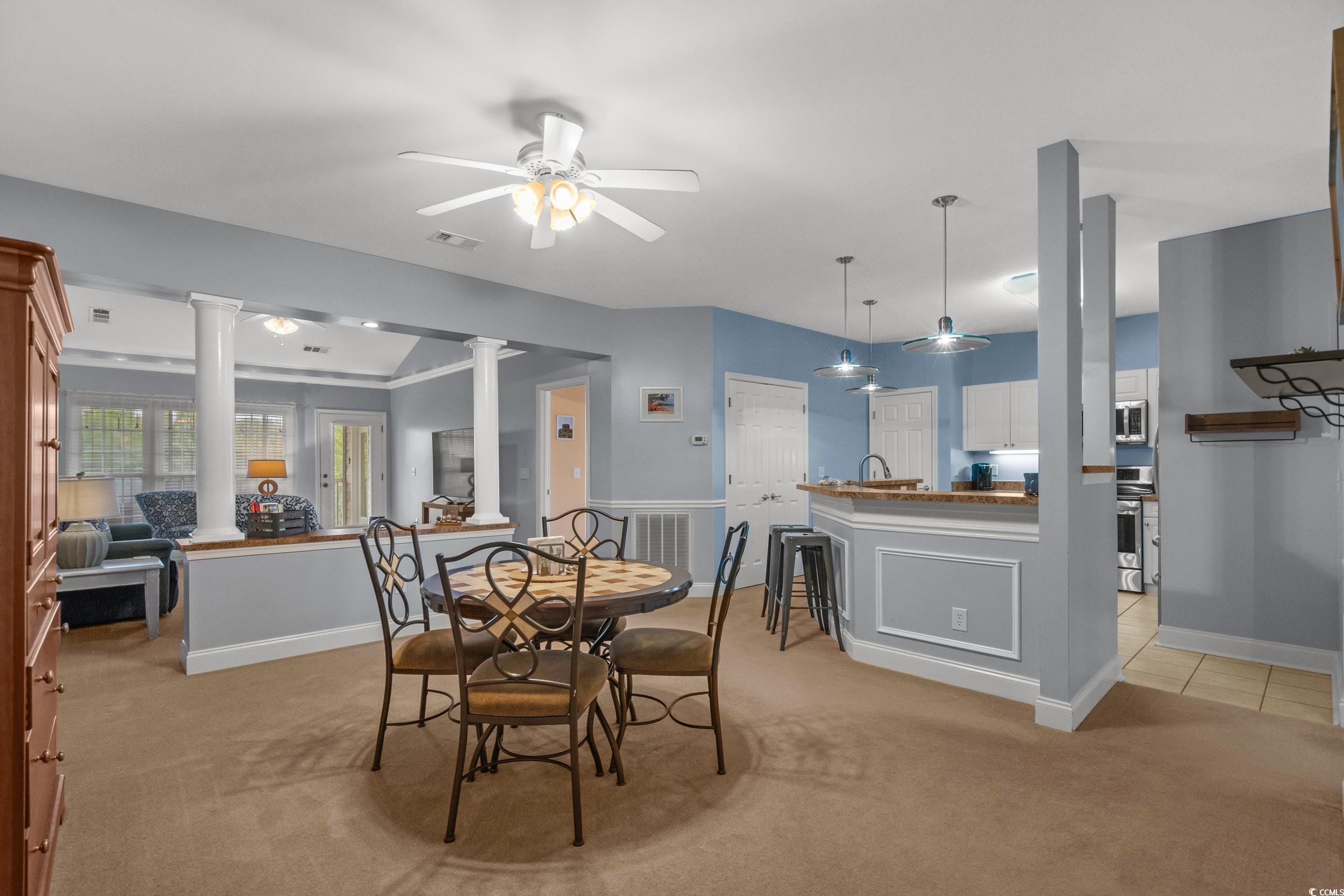 70 Addison Cottage Way, Unit 322 Murrells Inlet, SC 29576 - Photo 15 of 40 Dining area with light carpet, ceiling fan, and ornate columns