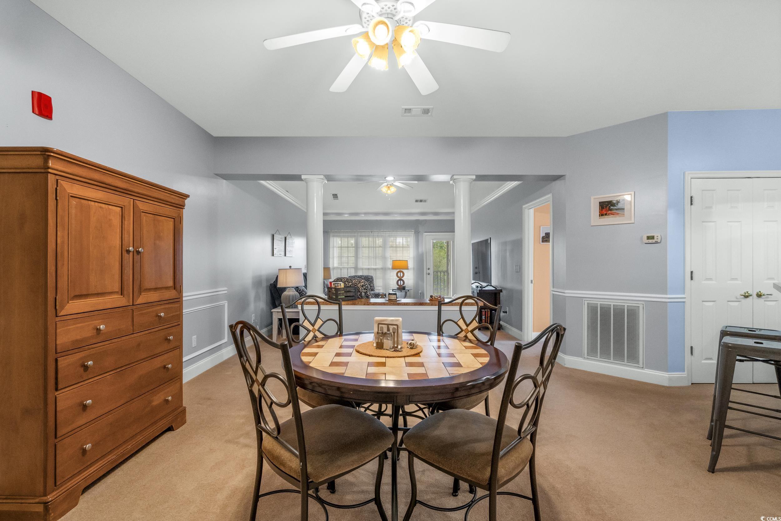 70 Addison Cottage Way, Unit 322 Murrells Inlet, SC 29576 - Photo 16 of 40 Dining room featuring a ceiling fan, light carpet, and decorative columns