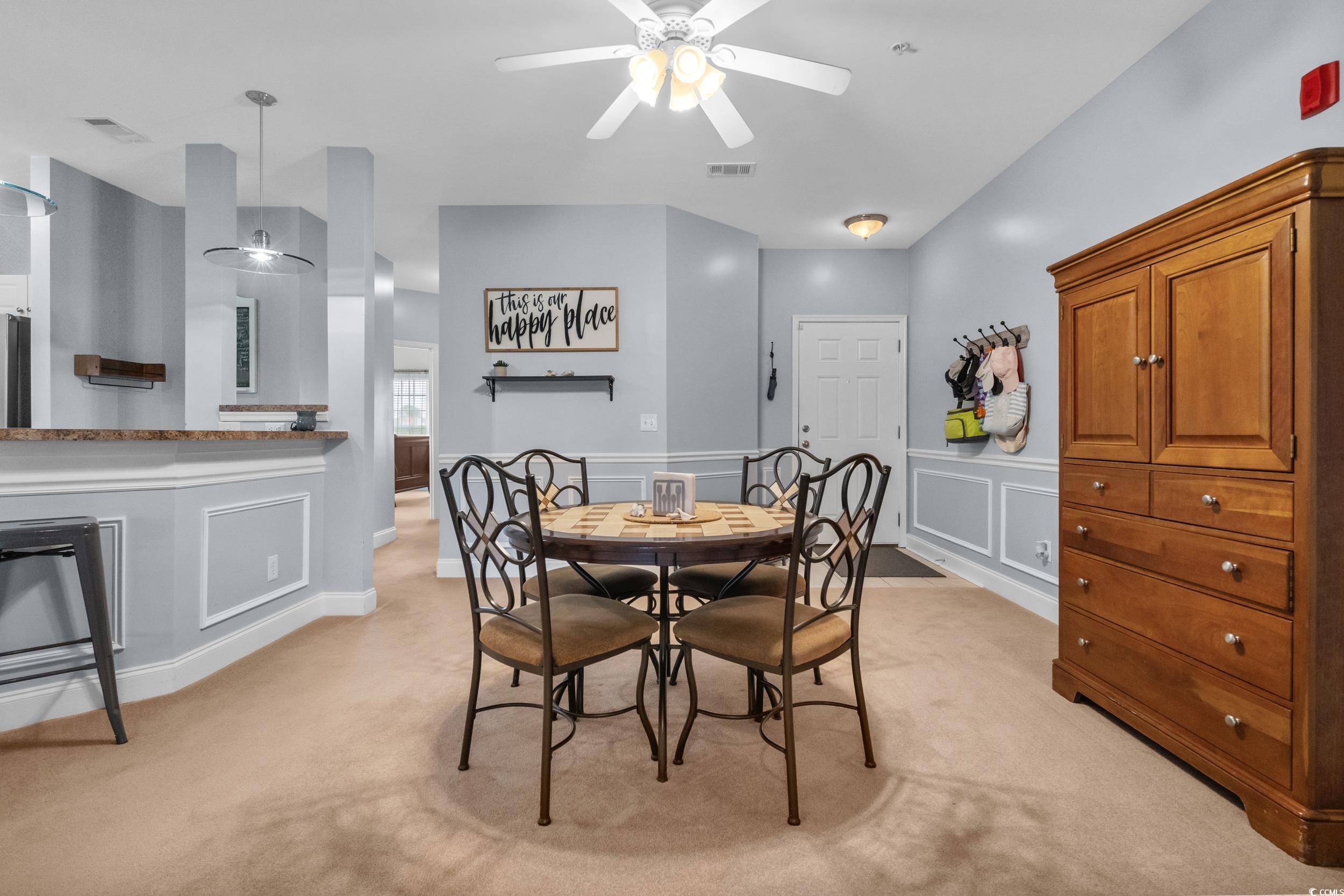 70 Addison Cottage Way, Unit 322 Murrells Inlet, SC 29576 - Photo 17 of 40 Dining room with light carpet, a ceiling fan, a decorative wall, and a wainscoted wall