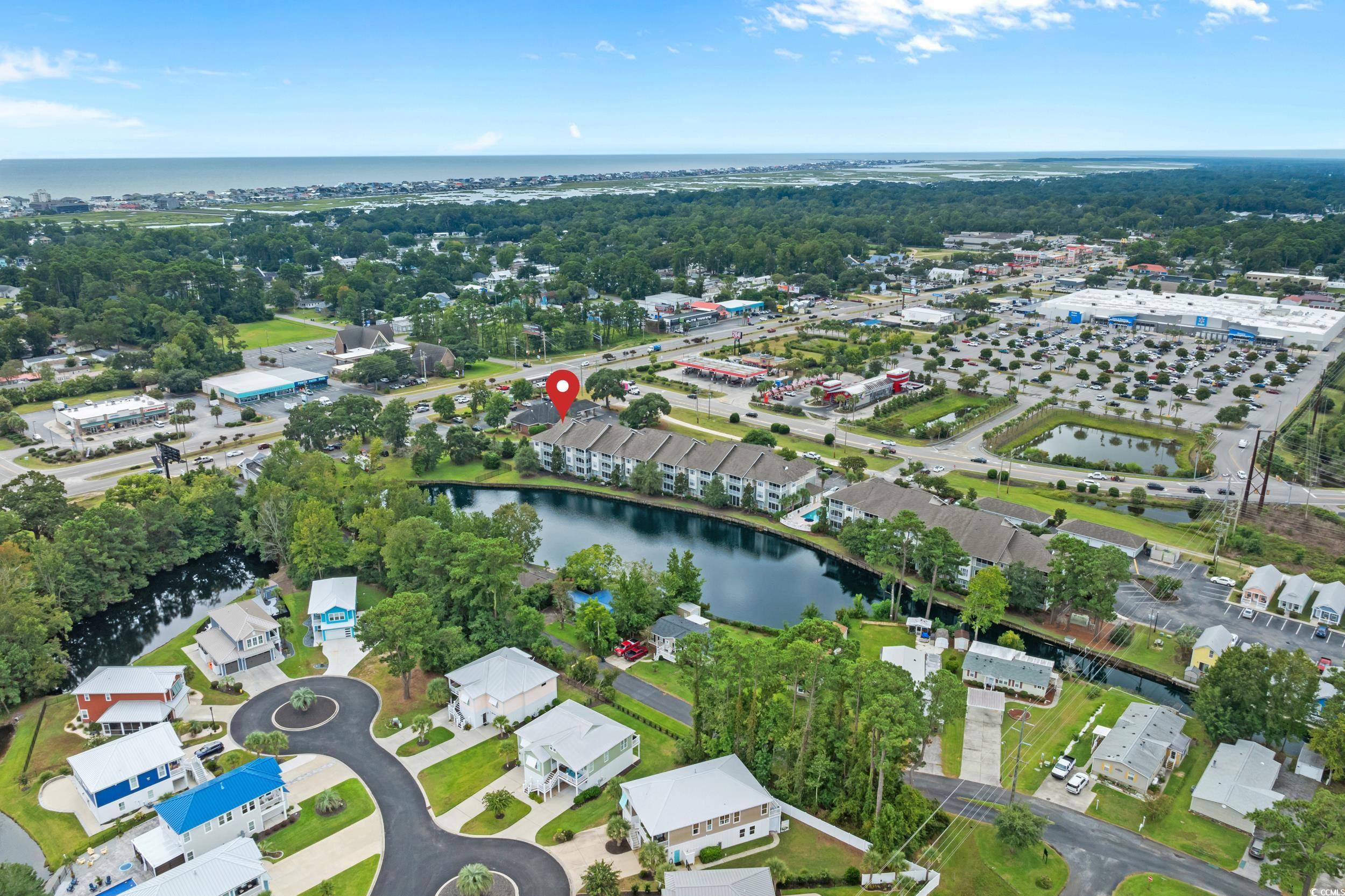 70 Addison Cottage Way, Unit 322 Murrells Inlet, SC 29576 - Photo 2 of 40 Aerial overview of property's location featuring a large body of water and a tree filled landscape