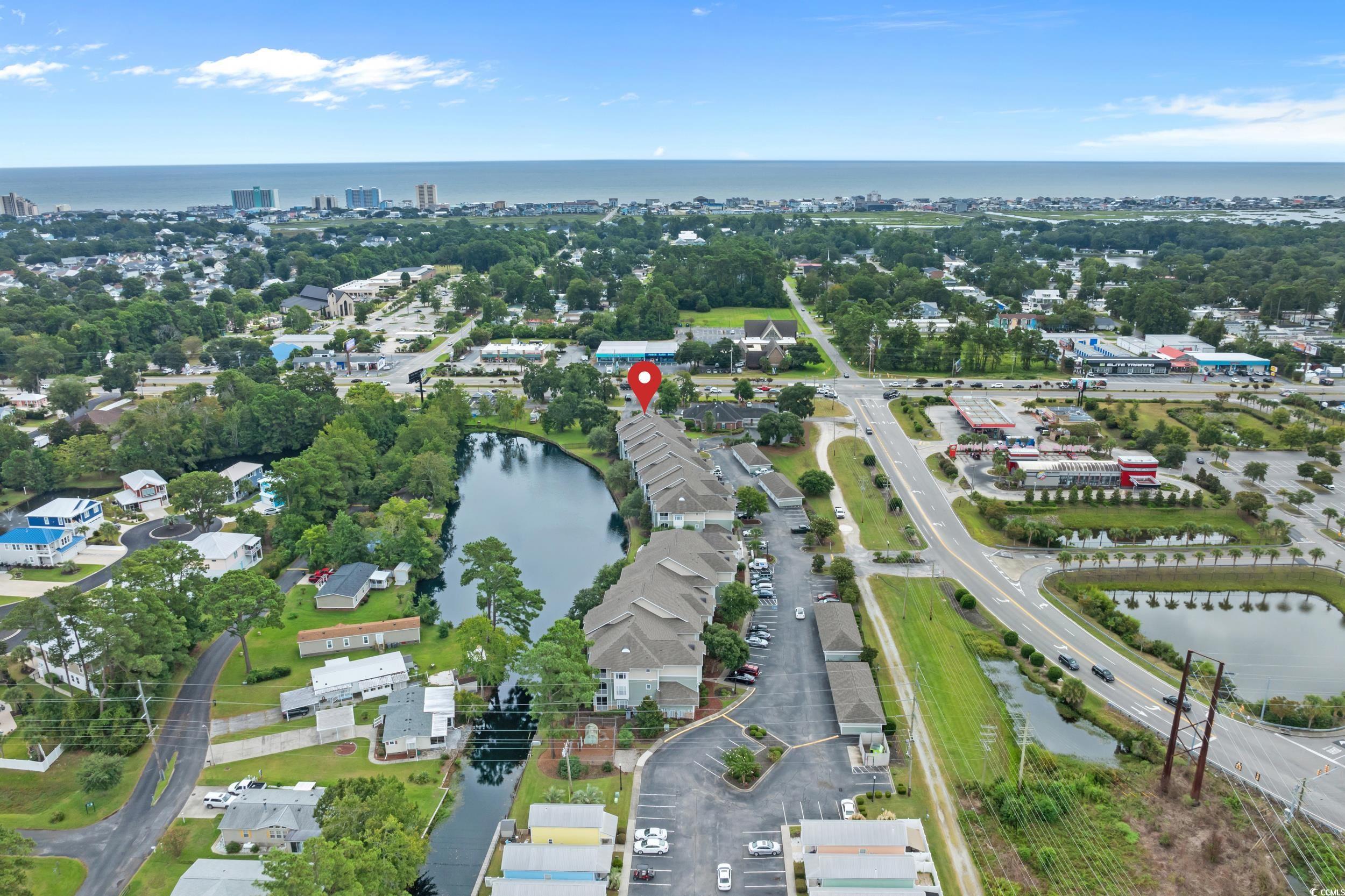 70 Addison Cottage Way, Unit 322 Murrells Inlet, SC 29576 - Photo 33 of 40 Aerial view of property and surrounding area featuring a large body of water and a tree filled landscape