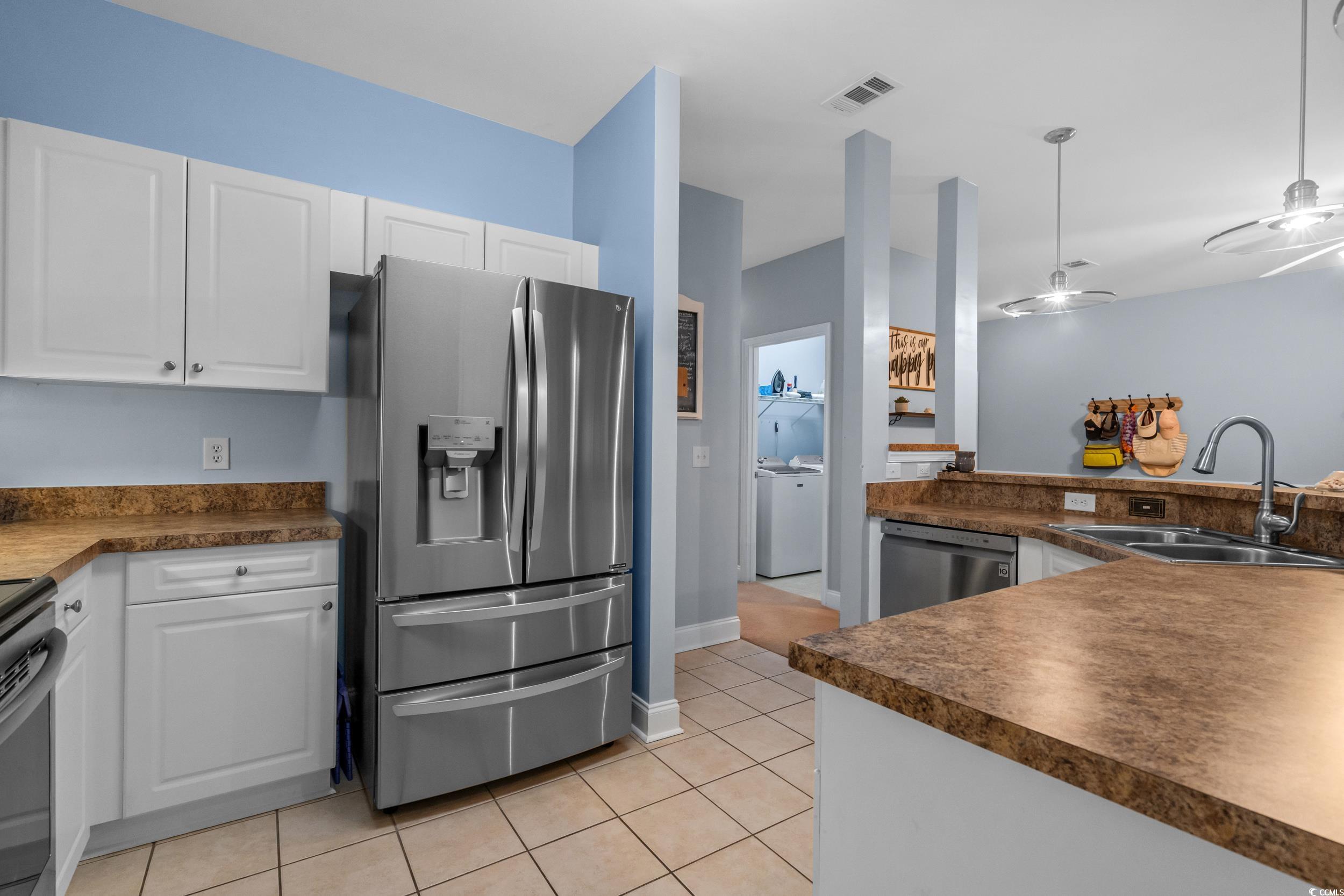 70 Addison Cottage Way, Unit 322 Murrells Inlet, SC 29576 - Photo 5 of 40 Kitchen featuring stainless steel appliances, light tile patterned floors, white cabinets, and dark countertops