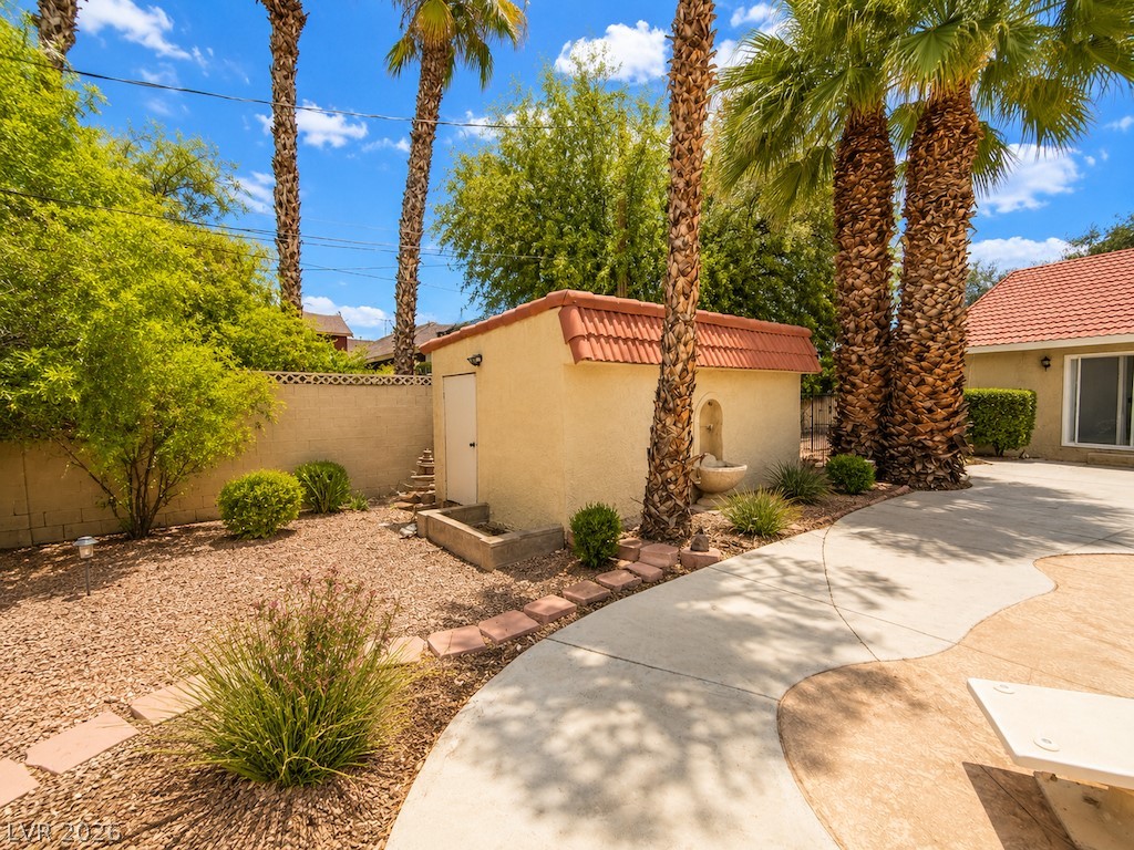 3010 East Viking Road Las Vegas, NV 89121 - Photo 44 of 48 A quaint garden shed with a fountain nestled among tall palms and mature landscaping.