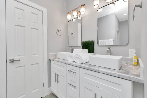 a bathroom with a granite countertop sink a mirror and shower