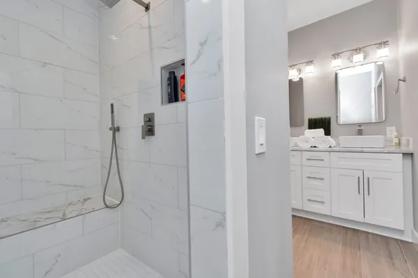 a bathroom with a double vanity sink mirror and shower