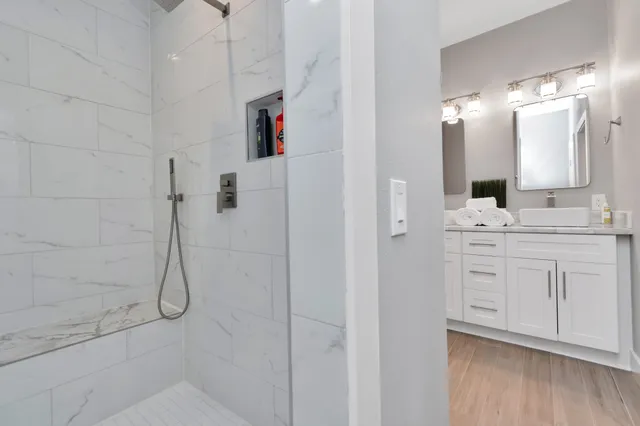 a bathroom with a double vanity sink mirror and shower