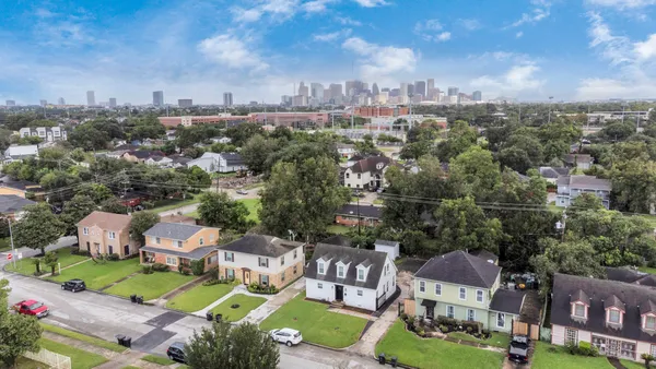 an aerial view of a city with lots of residential buildings ocean and mountain view in back