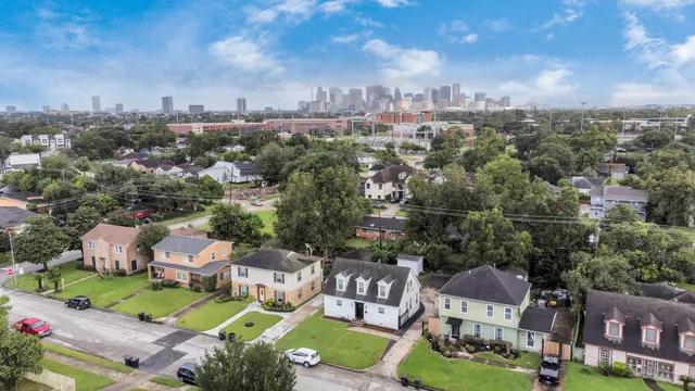 an aerial view of a city with lots of residential buildings ocean and mountain view in back