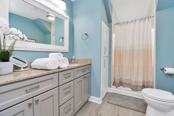 a spacious bathroom with a granite countertop sink toilet and shower
