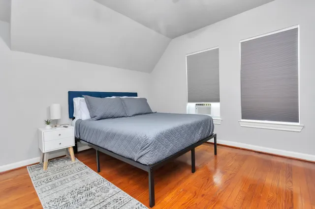 a bedroom with a bed and wooden floor