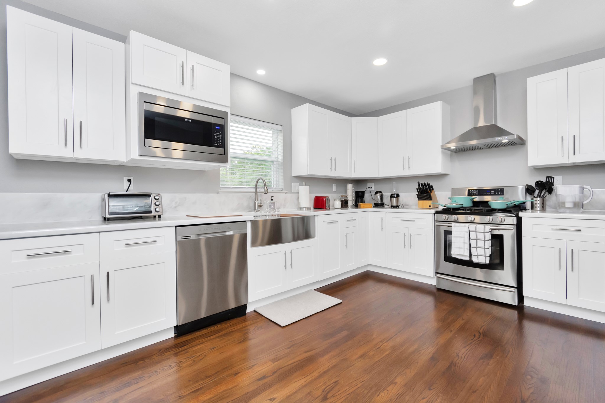 3315 Rosedale Street Houston, TX 77004 - Photo 9 of 32 a kitchen with cabinets stainless steel appliances and wooden floor