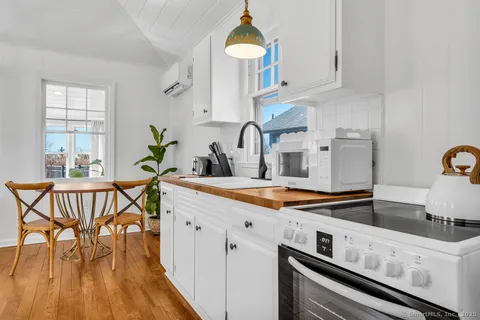 a kitchen with a dining table chairs and white cabinets