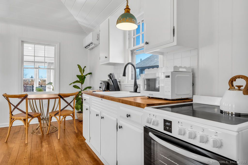 69 Waterside Lane, Unit 3 Clinton, CT 06413 - Photo 1 of 18 a kitchen with a dining table chairs and white cabinets