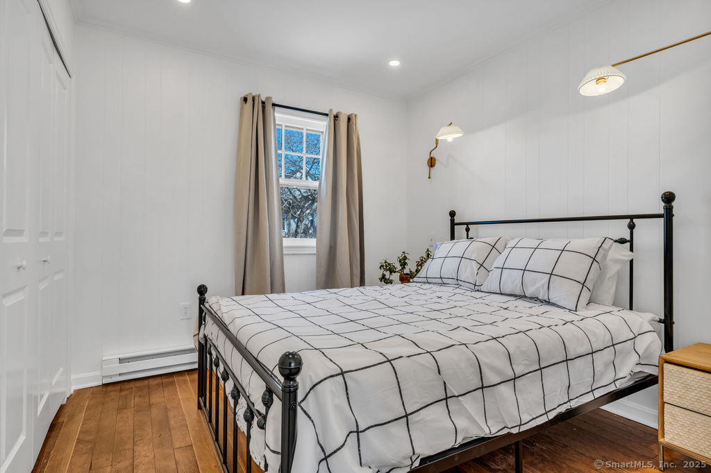 69 Waterside Lane, Unit 3 Clinton, CT 06413 - Photo 3 of 18 a bedroom with a bed and wooden floor