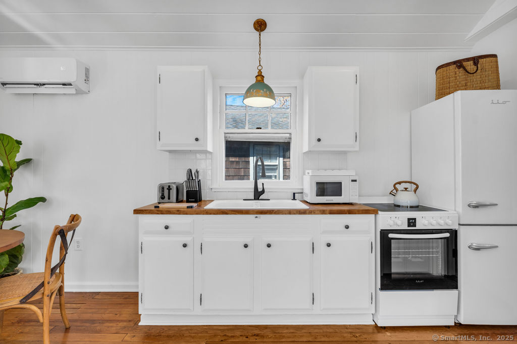 69 Waterside Lane, Unit 3 Clinton, CT 06413 - Photo 4 of 18 a kitchen with stainless steel appliances a white cabinets and wooden floor
