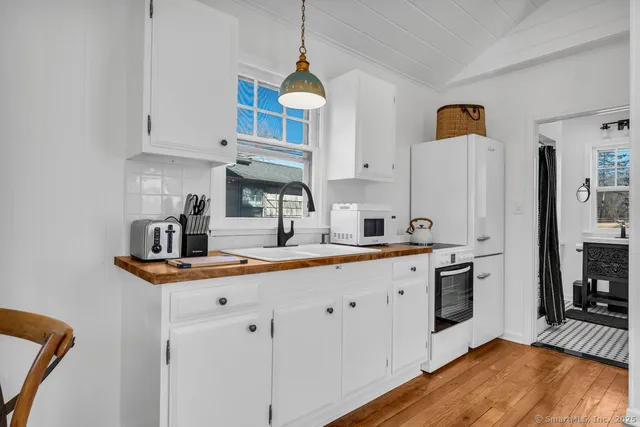 a kitchen with stainless steel appliances a sink a stove a refrigerator and cabinets