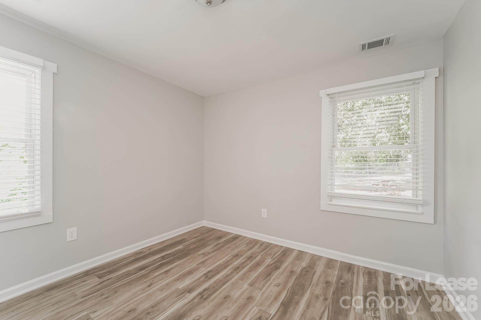 2824 Beech Nut Road Charlotte, NC 28208 - Photo 12 of 16 a view of an empty room with wooden floor and a window