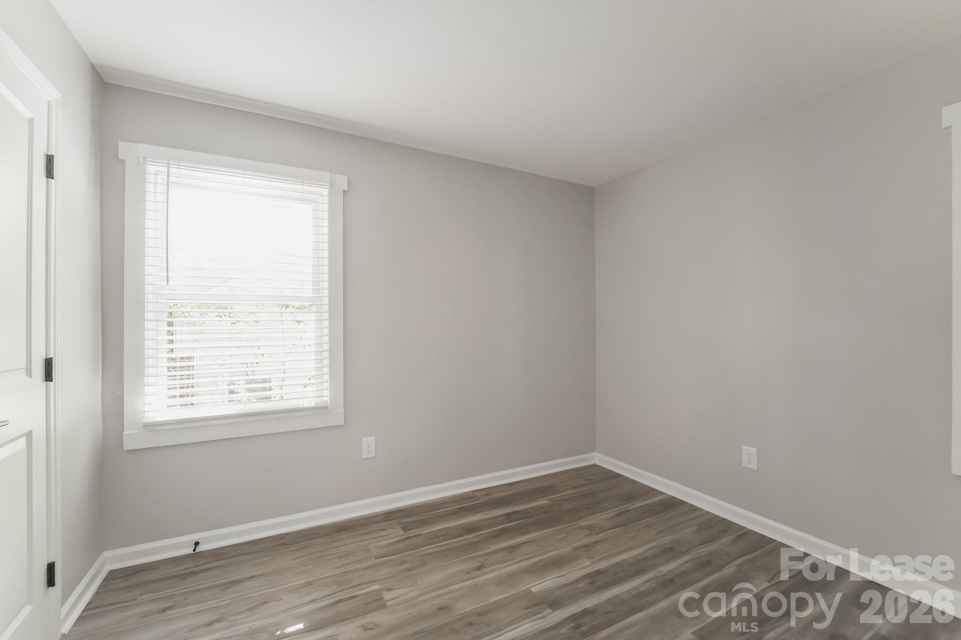 2824 Beech Nut Road Charlotte, NC 28208 - Photo 13 of 16 a view of an empty room with wooden floor and a window