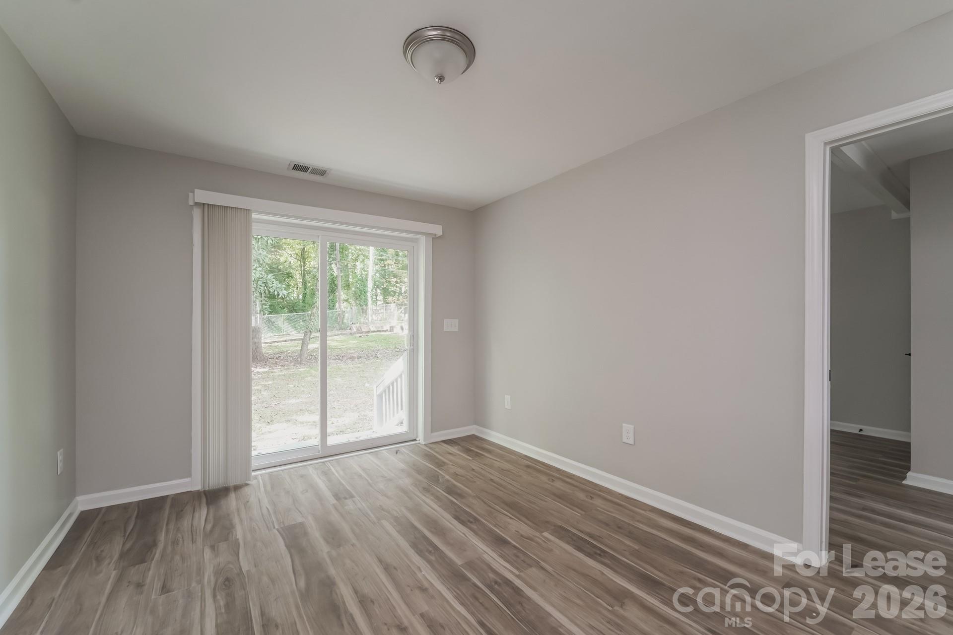 2824 Beech Nut Road Charlotte, NC 28208 - Photo 3 of 16 an empty room with wooden floor and windows