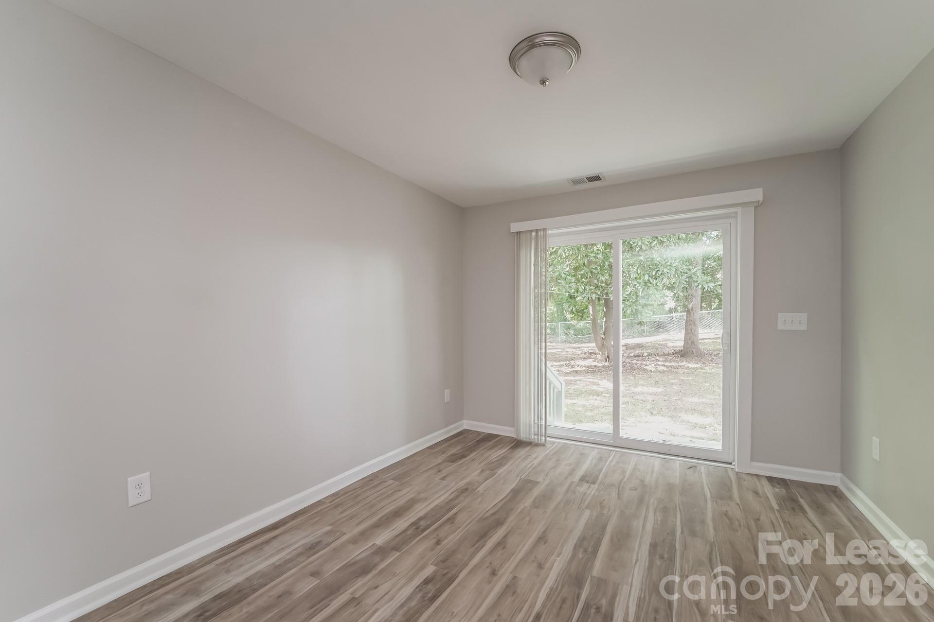 2824 Beech Nut Road Charlotte, NC 28208 - Photo 4 of 16 an empty room with wooden floor and windows