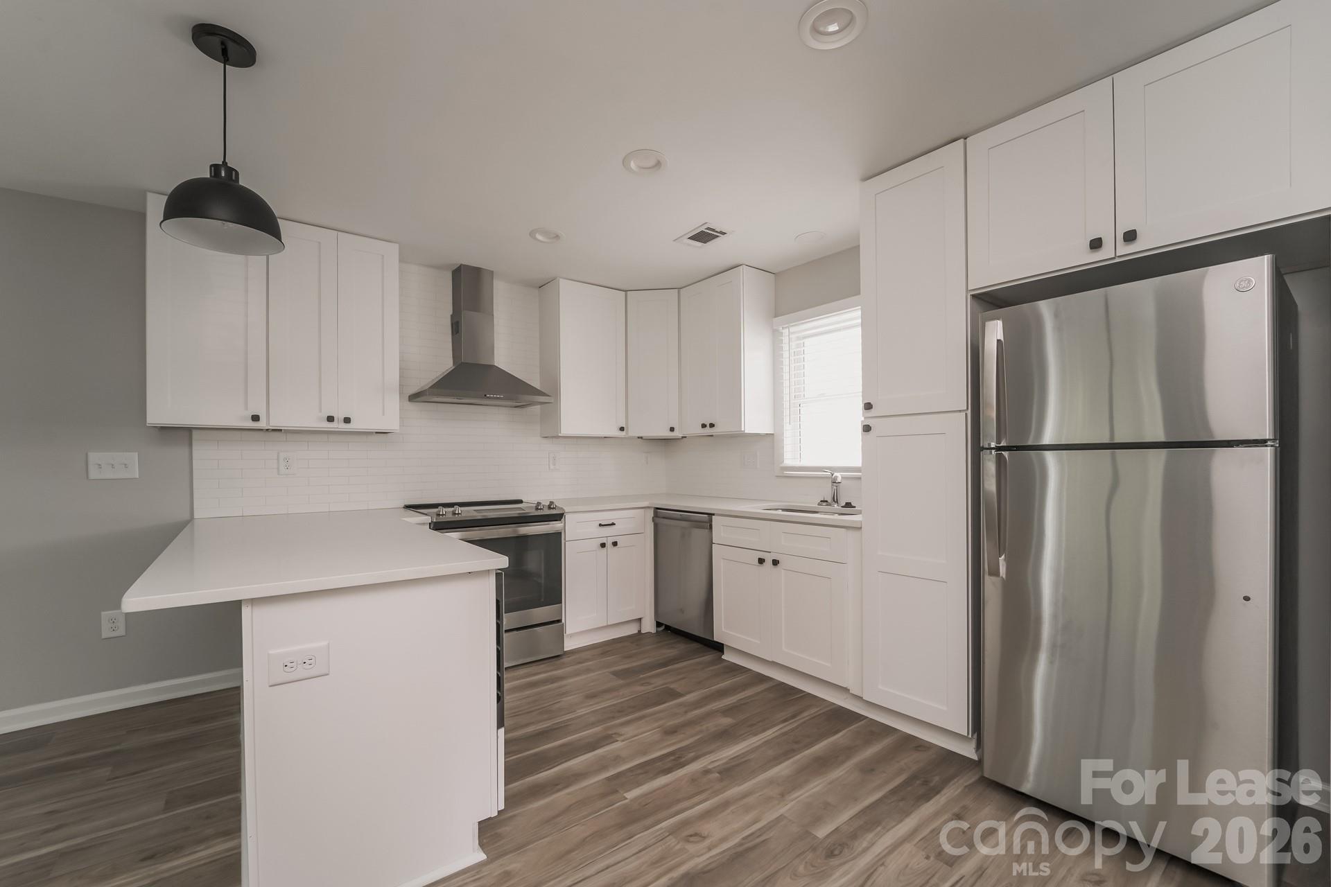 2824 Beech Nut Road Charlotte, NC 28208 - Photo 5 of 16 a kitchen with stainless steel appliances granite countertop a refrigerator a sink dishwasher a stove and white cabinets with wooden floor