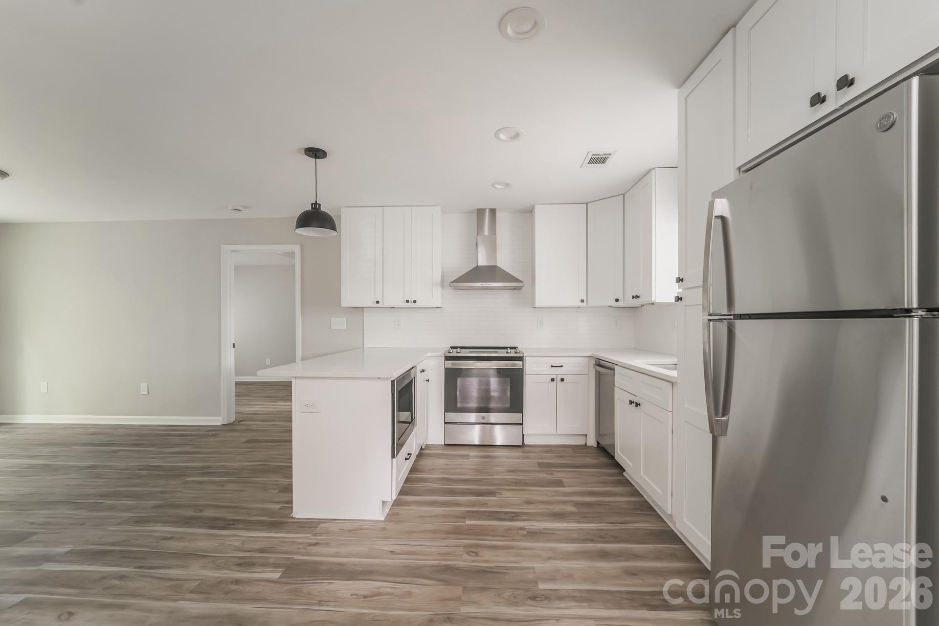 2824 Beech Nut Road Charlotte, NC 28208 - Photo 6 of 16 a kitchen with a refrigerator a stove top oven and white cabinets