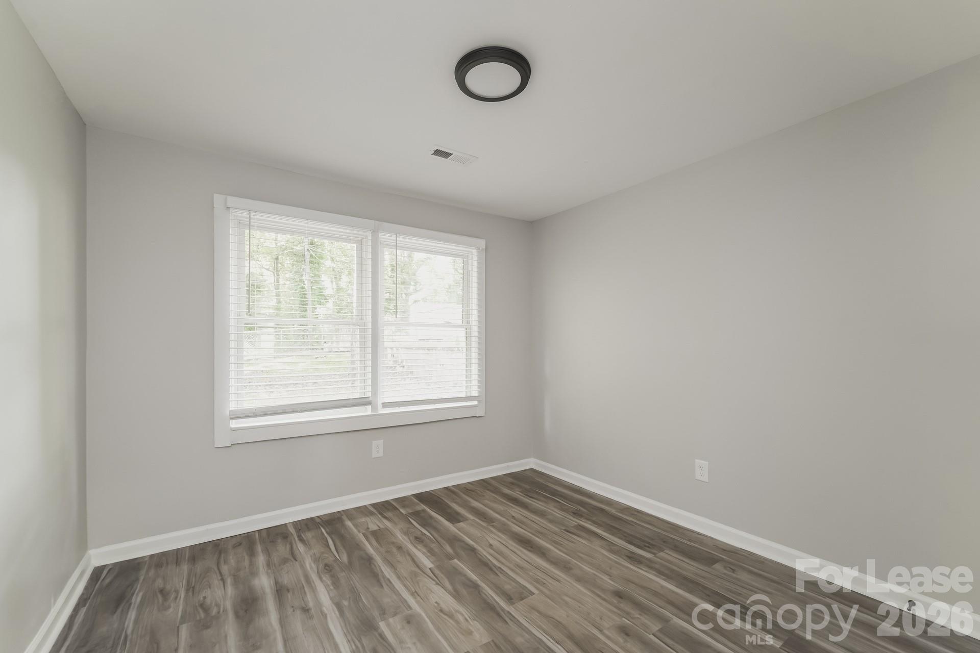 2824 Beech Nut Road Charlotte, NC 28208 - Photo 7 of 16 an empty room with wooden floor and windows