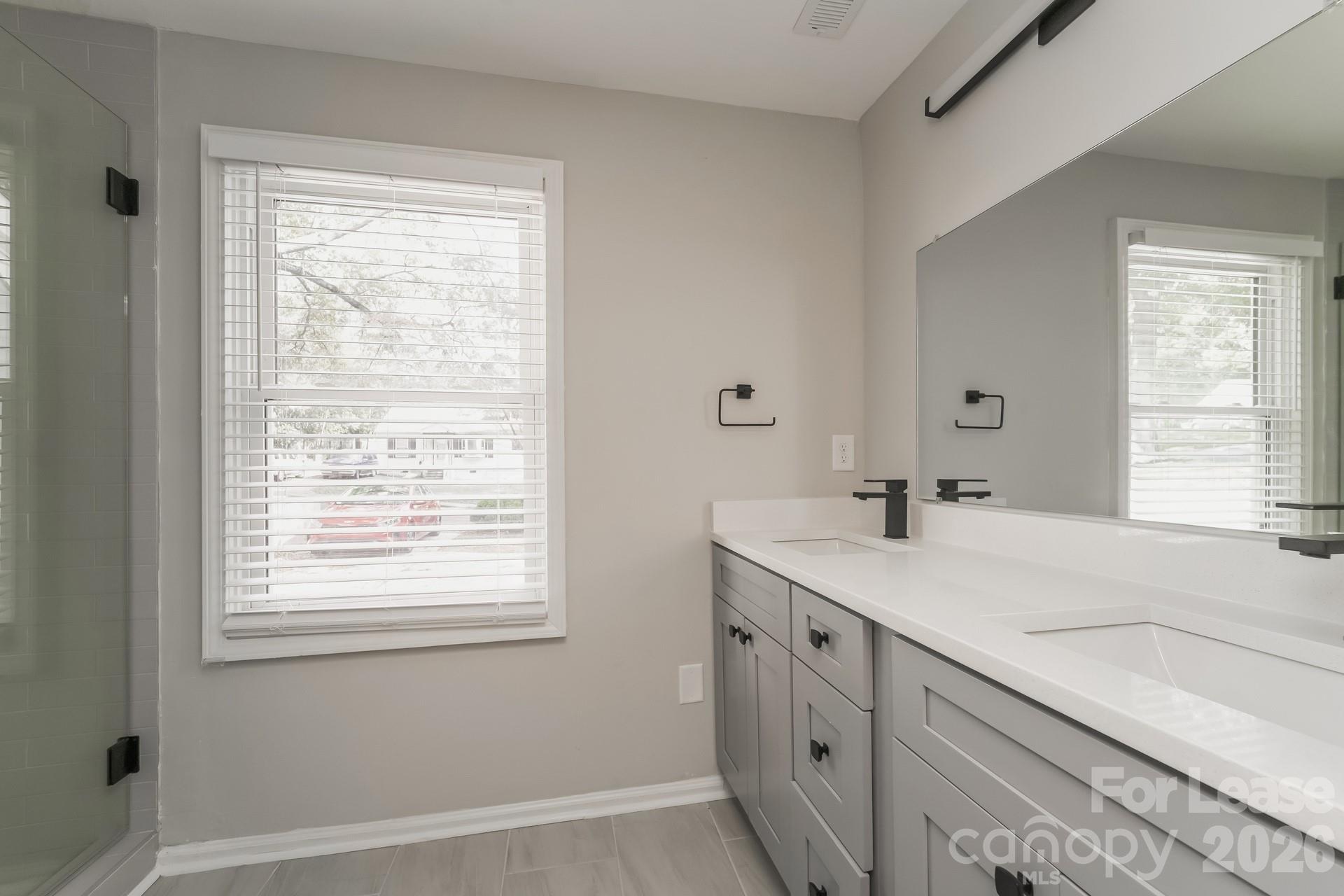 2824 Beech Nut Road Charlotte, NC 28208 - Photo 9 of 16 a bathroom with a sink a vanity and a window